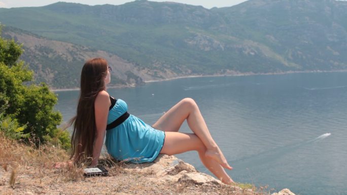 年轻女子在海边的山上放松