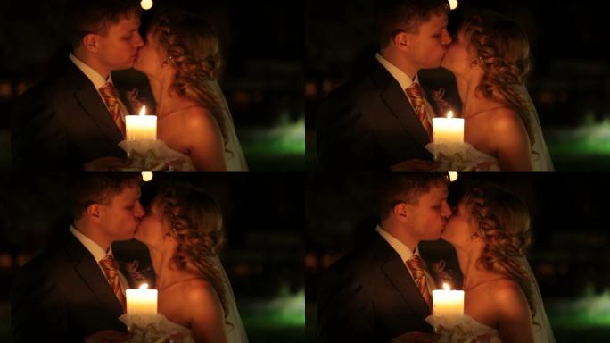 新婚夫妇晚上在烛光下接吻