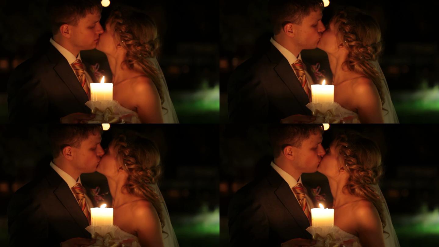 新婚夫妇晚上在烛光下接吻