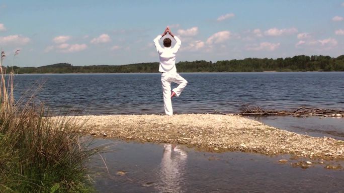 湖边练瑜伽的男人