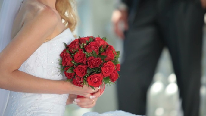 带着一束红色婚礼花束的新娘