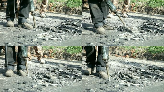 一名建筑工人用手提钻打碎道路上的沥青