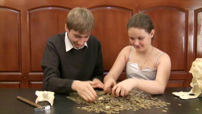 兄弟姐妹用硬币打碎了一个硬币盒。