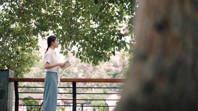 户外河边树荫公园女清晨看书翻书朗读教师节