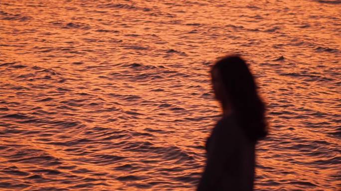 夕阳下海边女性剪影