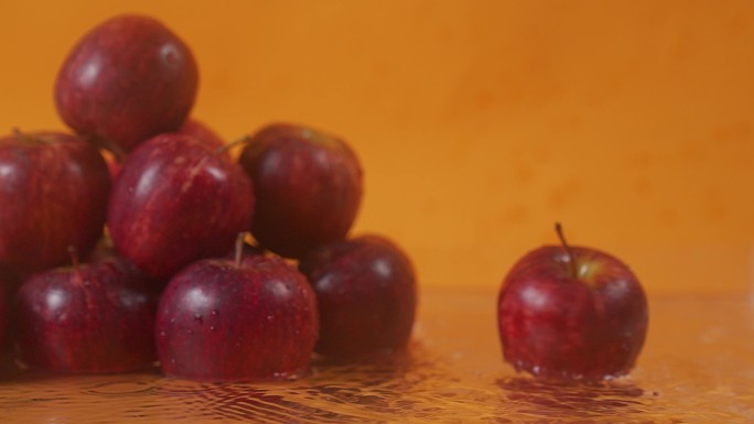 慢速红苹果水果苹果旋转掉落在水面上