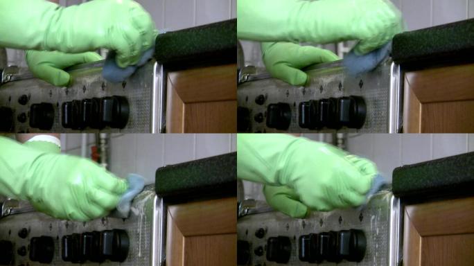戴手套的女人清洁煤气炉。