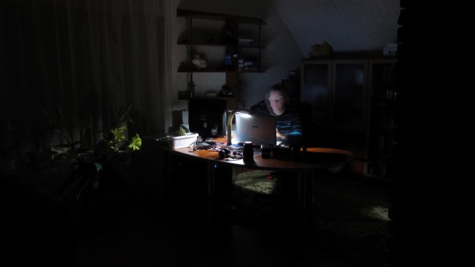 时间流逝。男人晚上在电脑上工作。