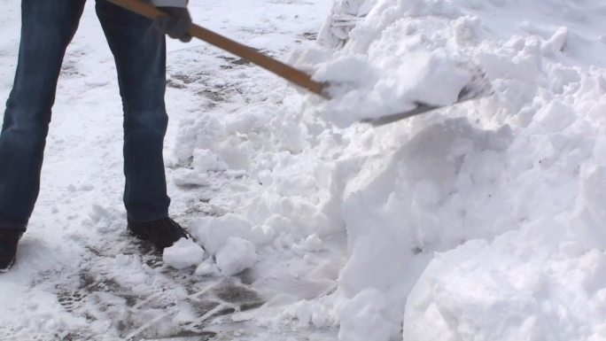 男人拿着一铲雪下雪