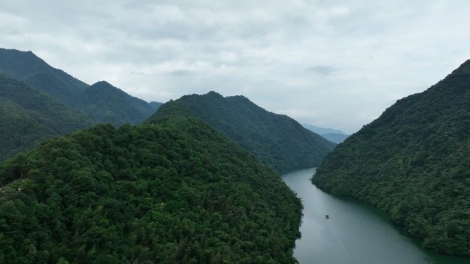 蓝天白云下行驶在桂林青狮潭水库峡谷中的船