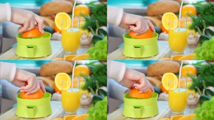 女性用手在榨汁机上挤橙汁