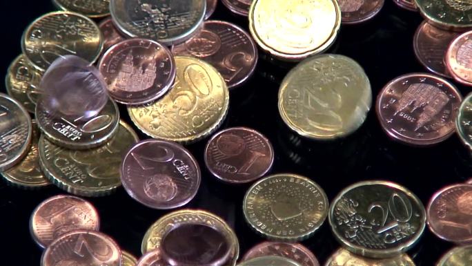 欧元硬币在桌子上竖着大拇指。