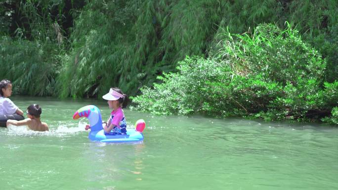 夏天坐着游泳圈在小河里玩水的女孩子