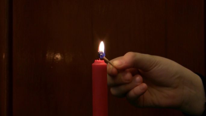 用火柴点蜡烛。