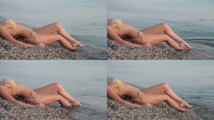 一个面目全非的女人穿着比基尼躺在海边的海滩上