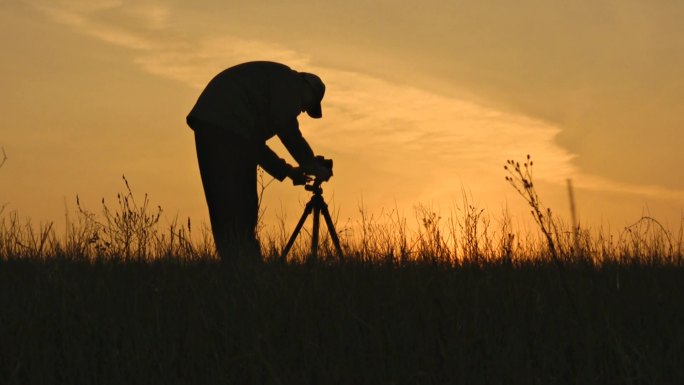 摄影师在夕阳下的剪影。