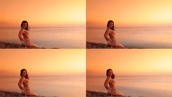 日落时穿着比基尼的年轻女子坐在海滩上