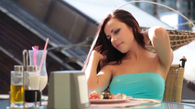 年轻女子在一家休闲的户外餐厅吃午餐