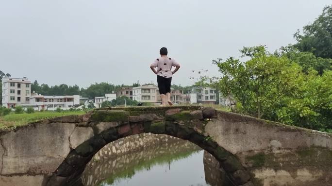 一个农妇在小石桥面上锻炼身体跳舞跳健身舞