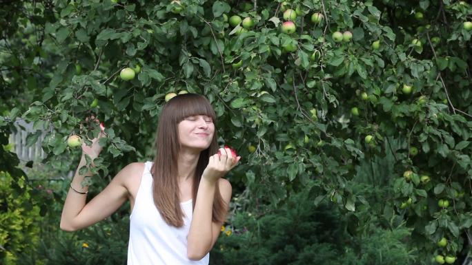 花园里吃红苹果的漂亮女孩