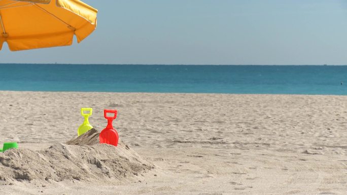 迈阿密南部海滩上的桑德伯格带着玩具和雨伞