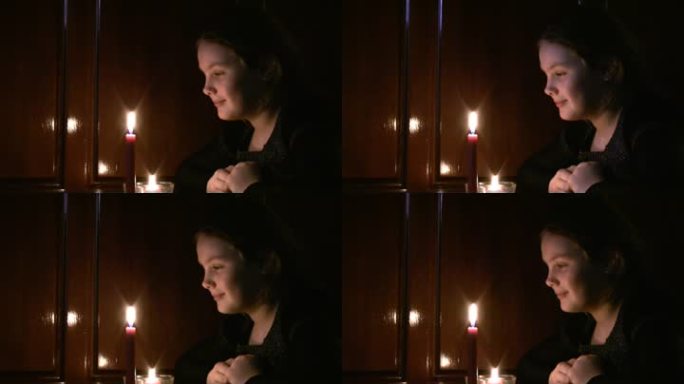少女看着燃烧的蜡烛。