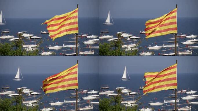 地中海旁的加泰罗尼亚大旗。在布拉瓦海岸边刮风的日子里，旗帜在风中飘扬。散焦船背景。