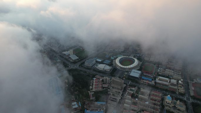 航拍平流雾云层之下的威海体育场