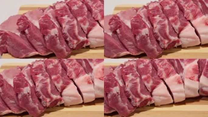 把新鲜猪肉切成薄片放在木砧板上