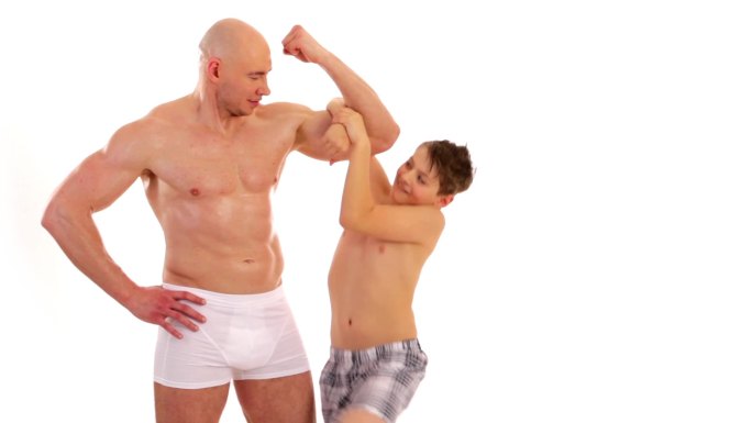 一个男孩羡慕地看着健美运动员的肌肉。一个男孩仰慕健美运动员的肌肉。