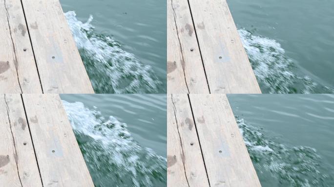 阳光下桂林青狮潭水上行驶的木船激起的浪花