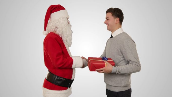 年轻的商人收到圣诞老人的礼物，与白人握手