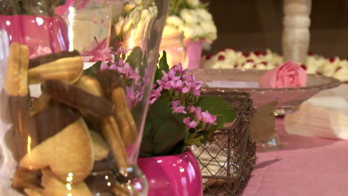 一套巧克力饼干，鲜花，蛋糕和蜡烛。婚礼配饰以柔软、优雅和粉色呈现。庆祝活动的装饰：特别活动、聚会或生