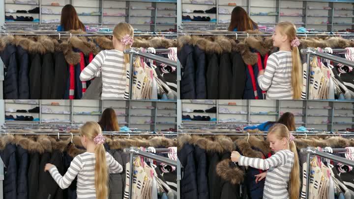 妈妈和女儿在一家服装店为女孩买衣服，孩子穿的夹克看起来最暖和。侧视图