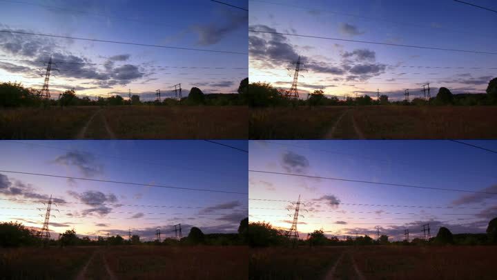 在一片平坦的风景和落日中，电线的轮廓。时间点。