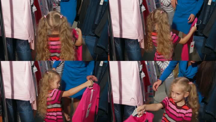 小女孩和家人在一家服装店买衣服