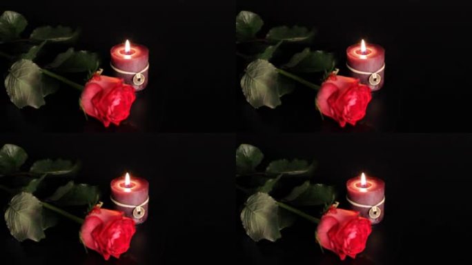 黑色背景上的红玫瑰和蜡烛。