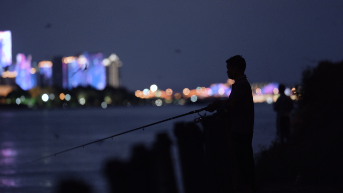 夜晚江边钓鱼的人