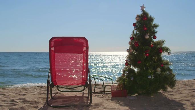 沙滩上的躺椅和圣诞树以及礼品盒