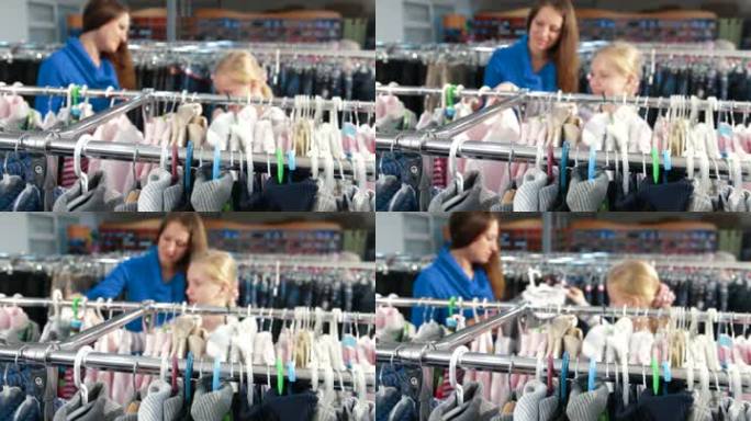 母亲和女儿在服装店买女孩的衣服，关注前景