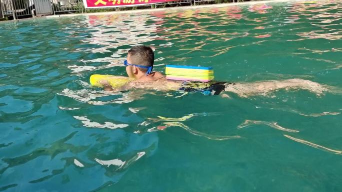 小学生署假参加少儿游泳训练班小孩子在游泳
