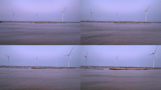 日出时分海边的风力发电机