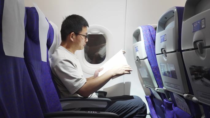 男子在飞机上看书学习