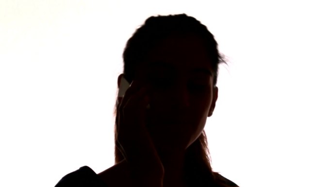 一个女人在用她的智能手机进行近黑白通话。女孩在工作时用手机聊天。家中的女性电话交谈。闲暇时用手机聊天