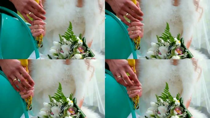 新娘和新郎手牵着手，戴着结婚戒指