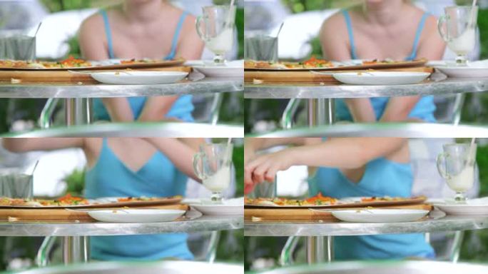 户外快餐店的小鸟在吃盘子里的披萨