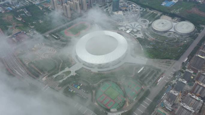 航拍枣庄新城云雾缭绕下的体育中心和山体