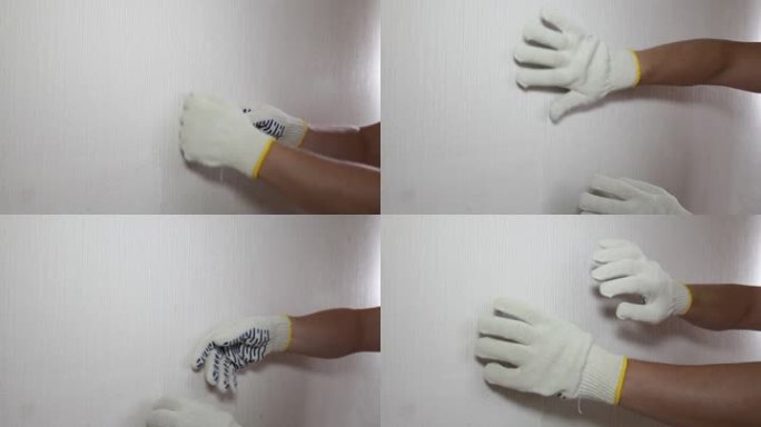 戴手套的男人展示如何移除旧墙纸