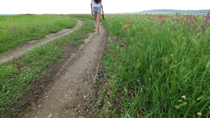 光着脚走在乡间小路上的年轻女子