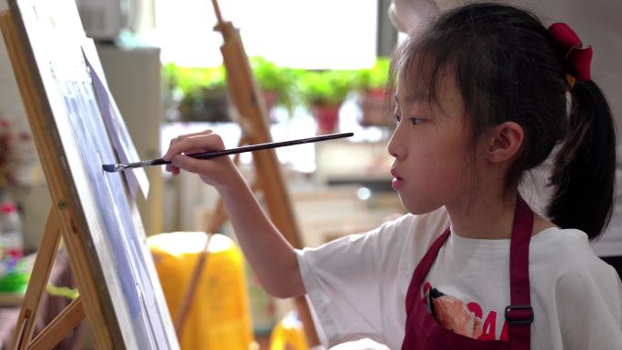 美术培训学校里正在画画的小女生学生